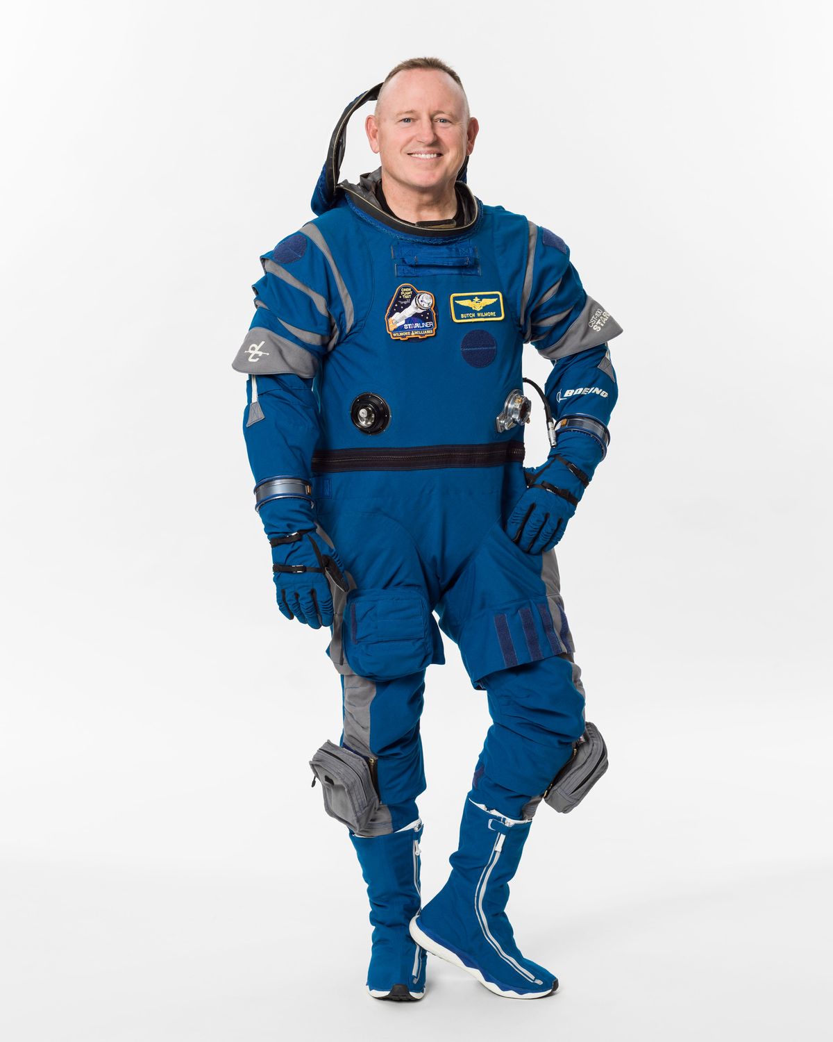 Wilmore in a blue space suit on a white background.