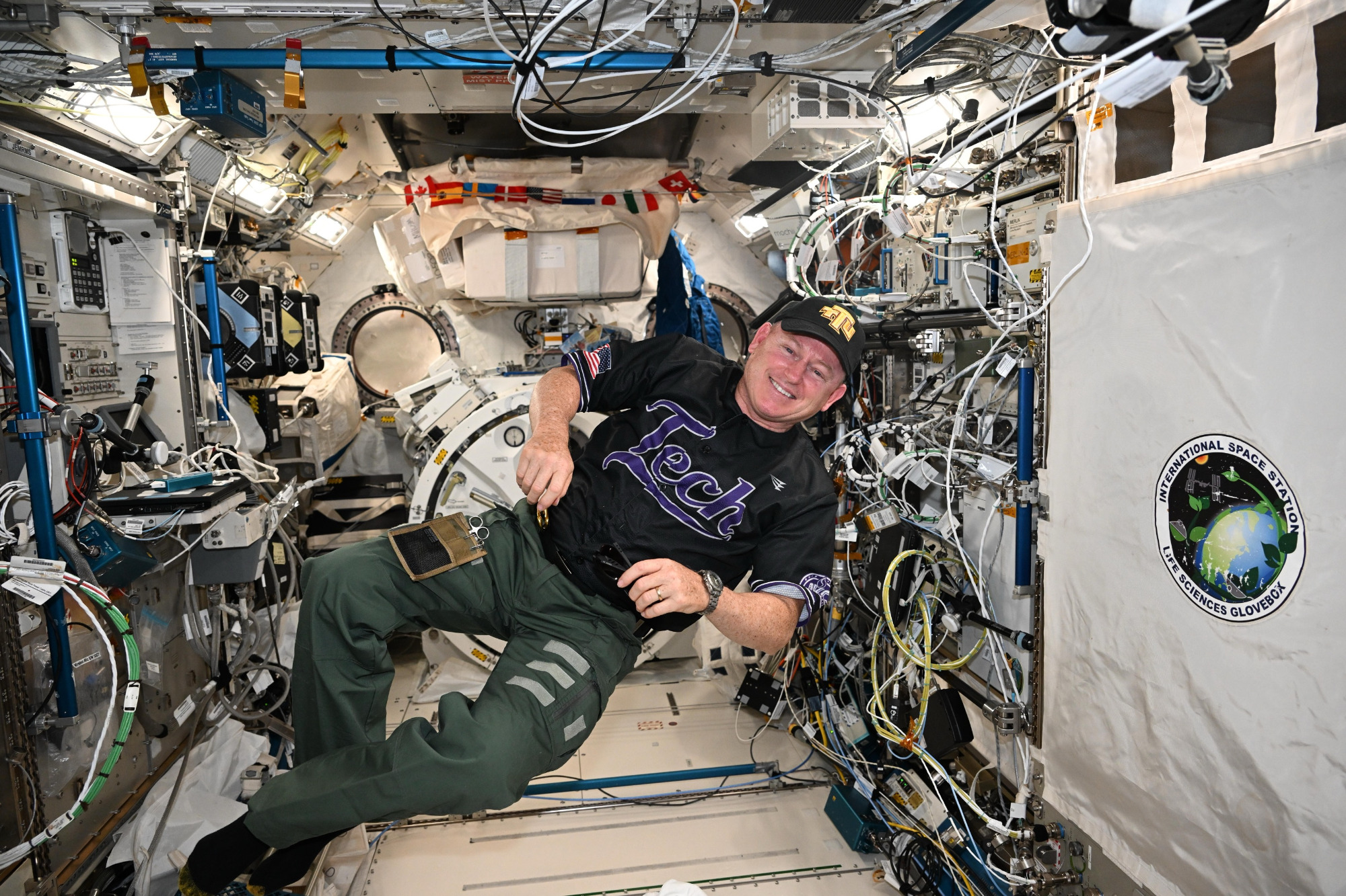 Wilmore floating and wearing a Tech shirt and baseball cap.