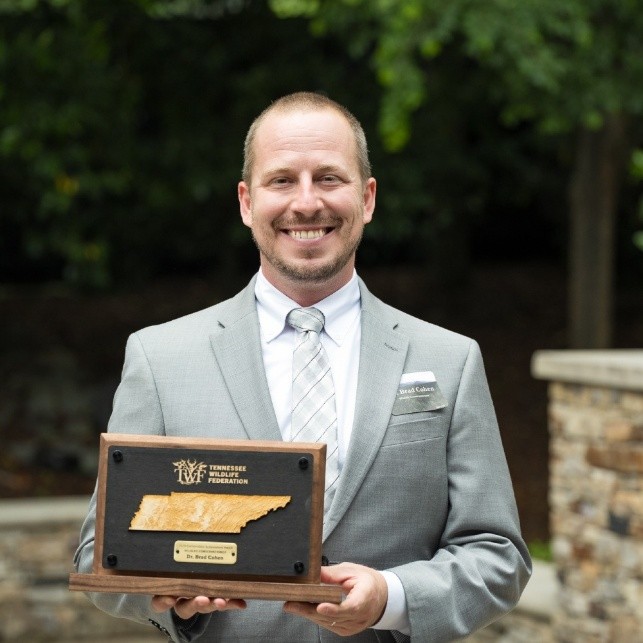 Dr. Brad Cohen holding an award