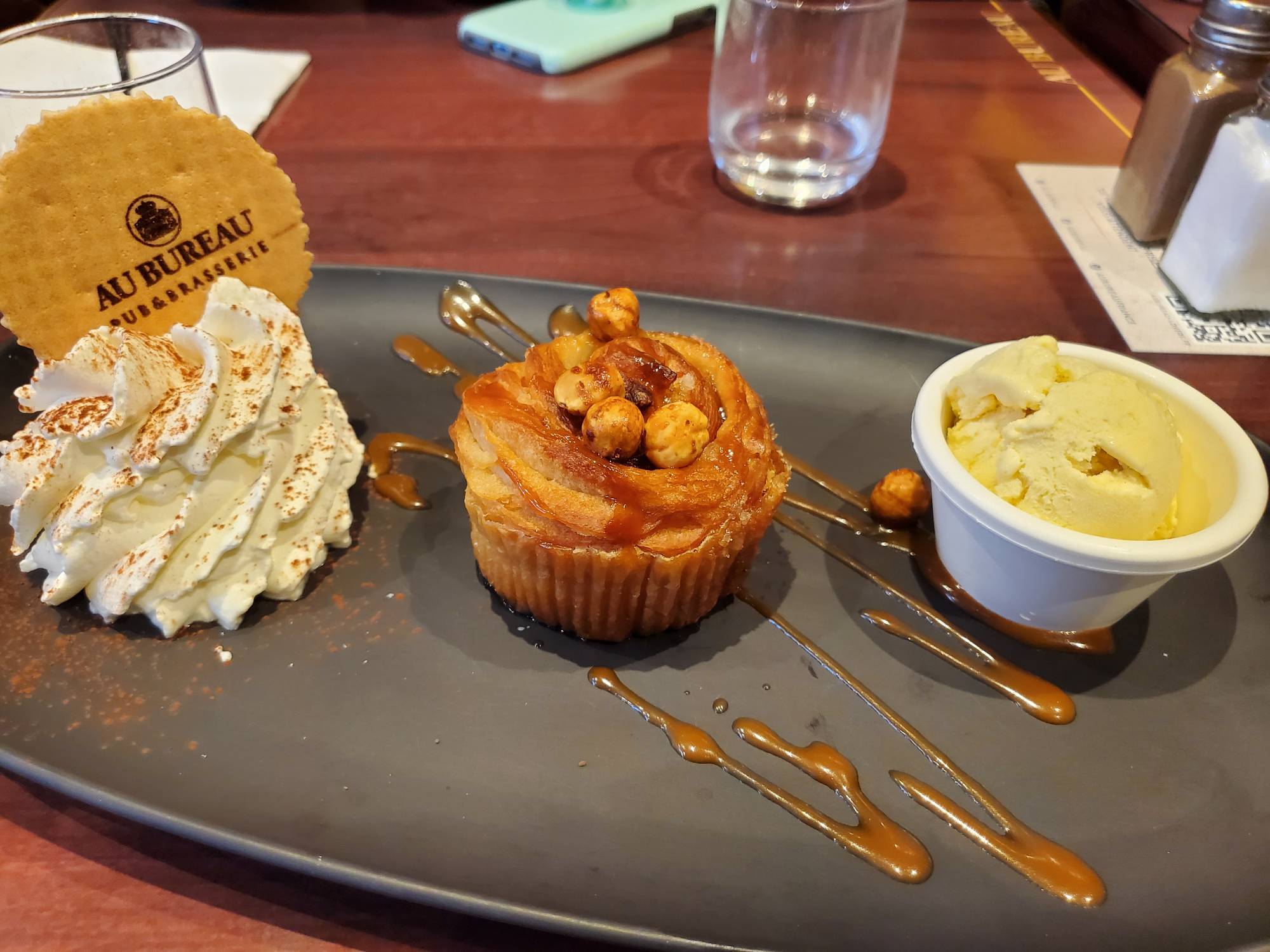 a dessert tray with whipped cream, a muffin, and a scoop of ice cream