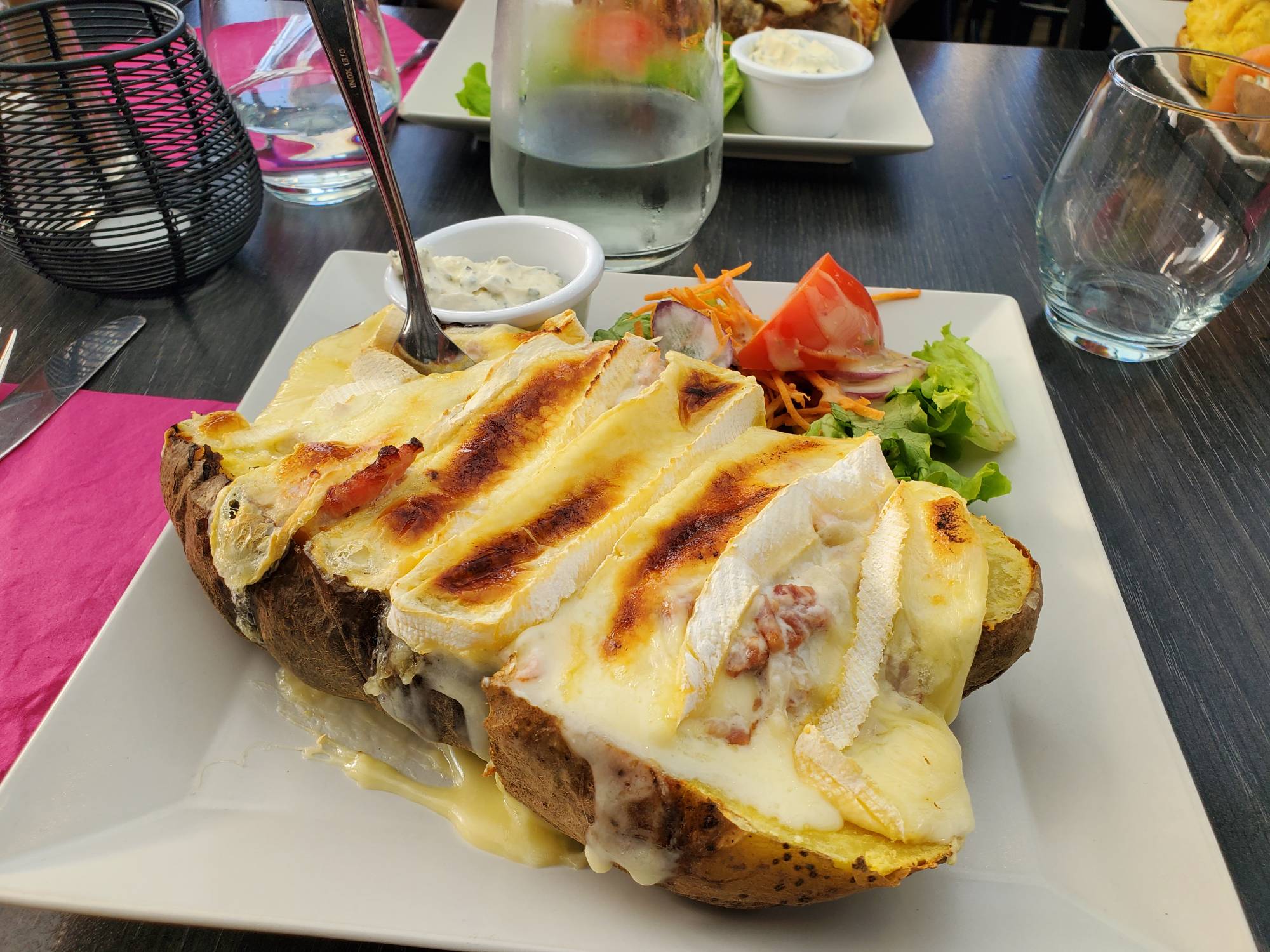 A potato baked with slices of brie on top