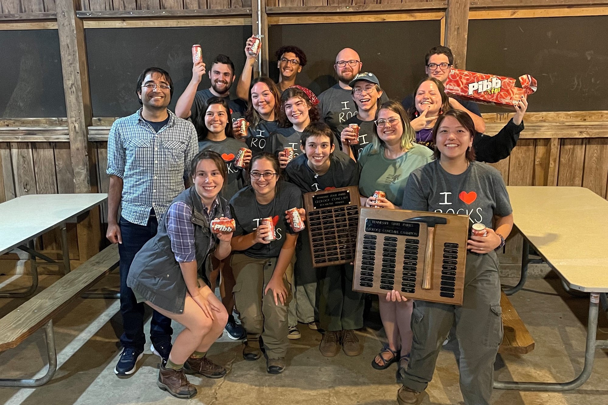 Earth Sciences faculty/students posing with GeoConclave trophy and case of Mr. Pibb