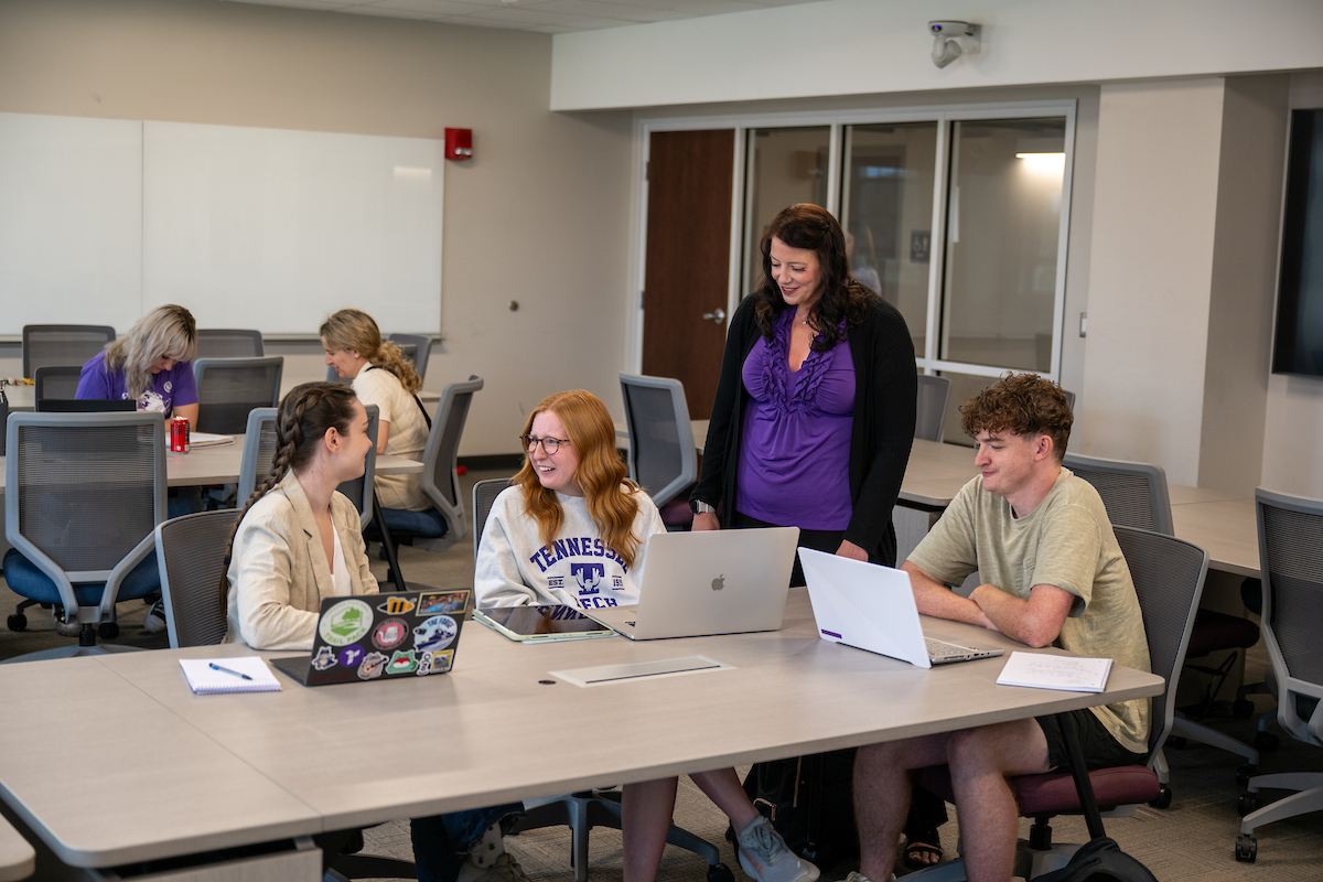 students studying with a professor