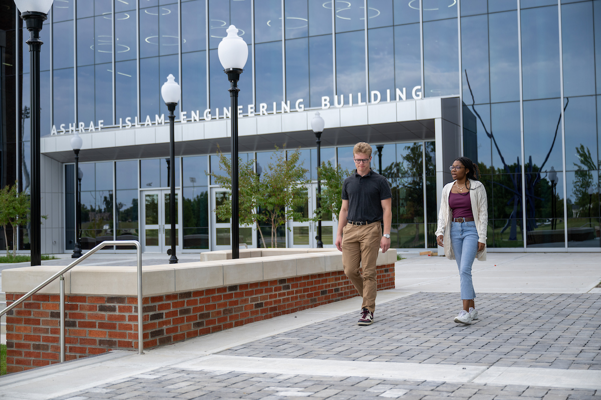 two students walking out front of the AIEC