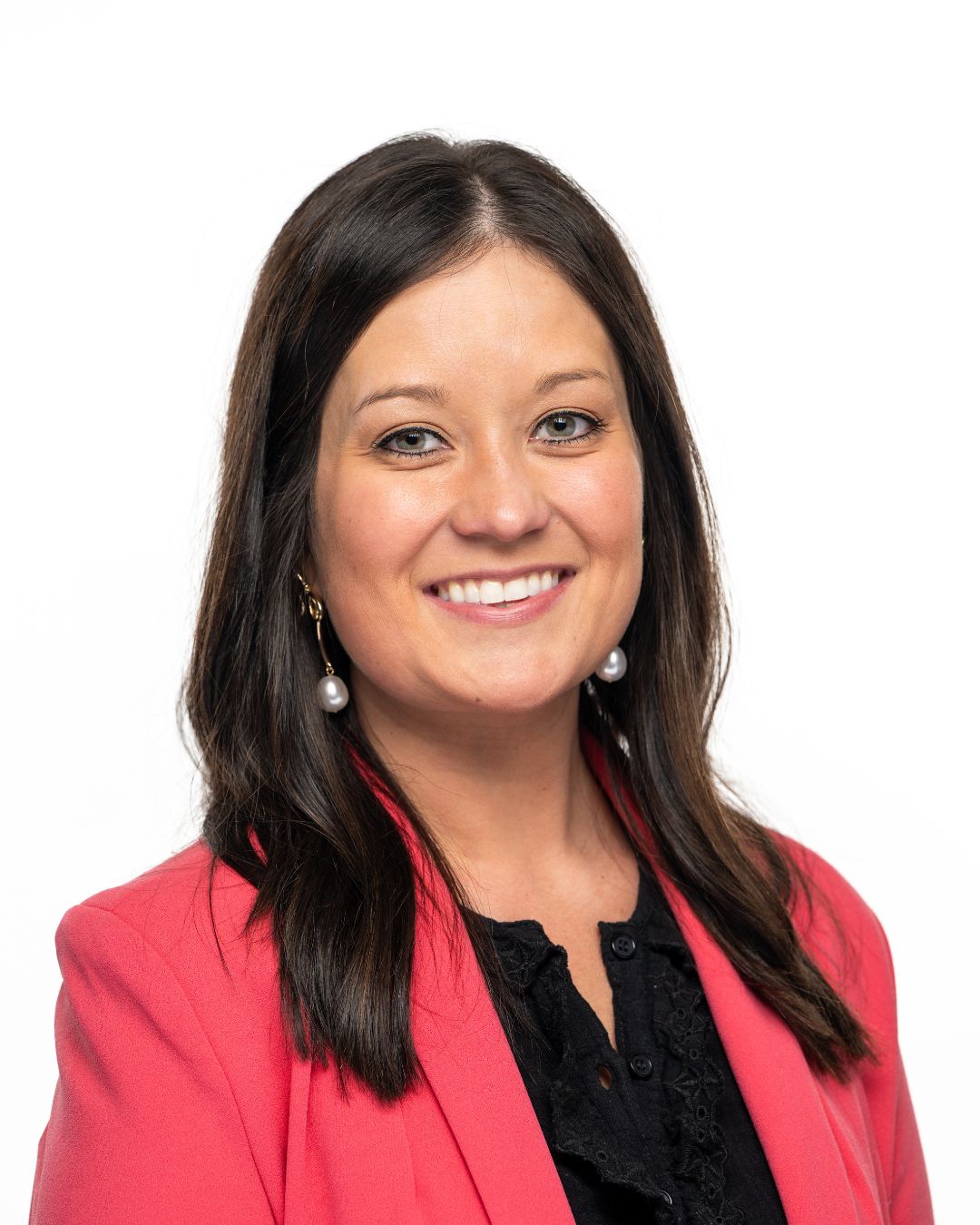 a headshot of a woman with smiling. she has on a pink blazer and a black top. 
