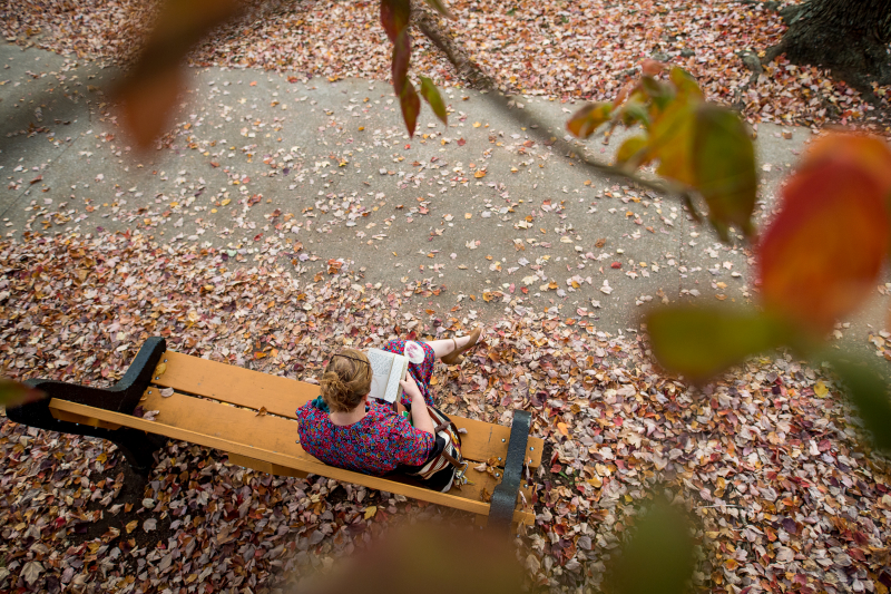 Girl sitting on main quad reading