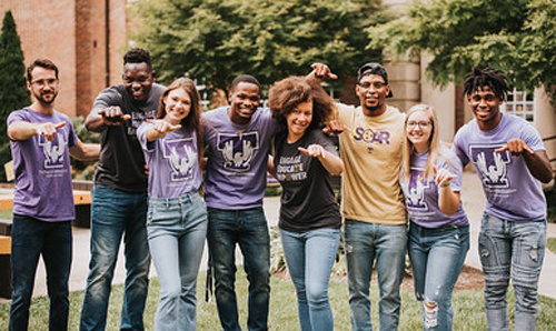 college of education students with wings gesture up displayed