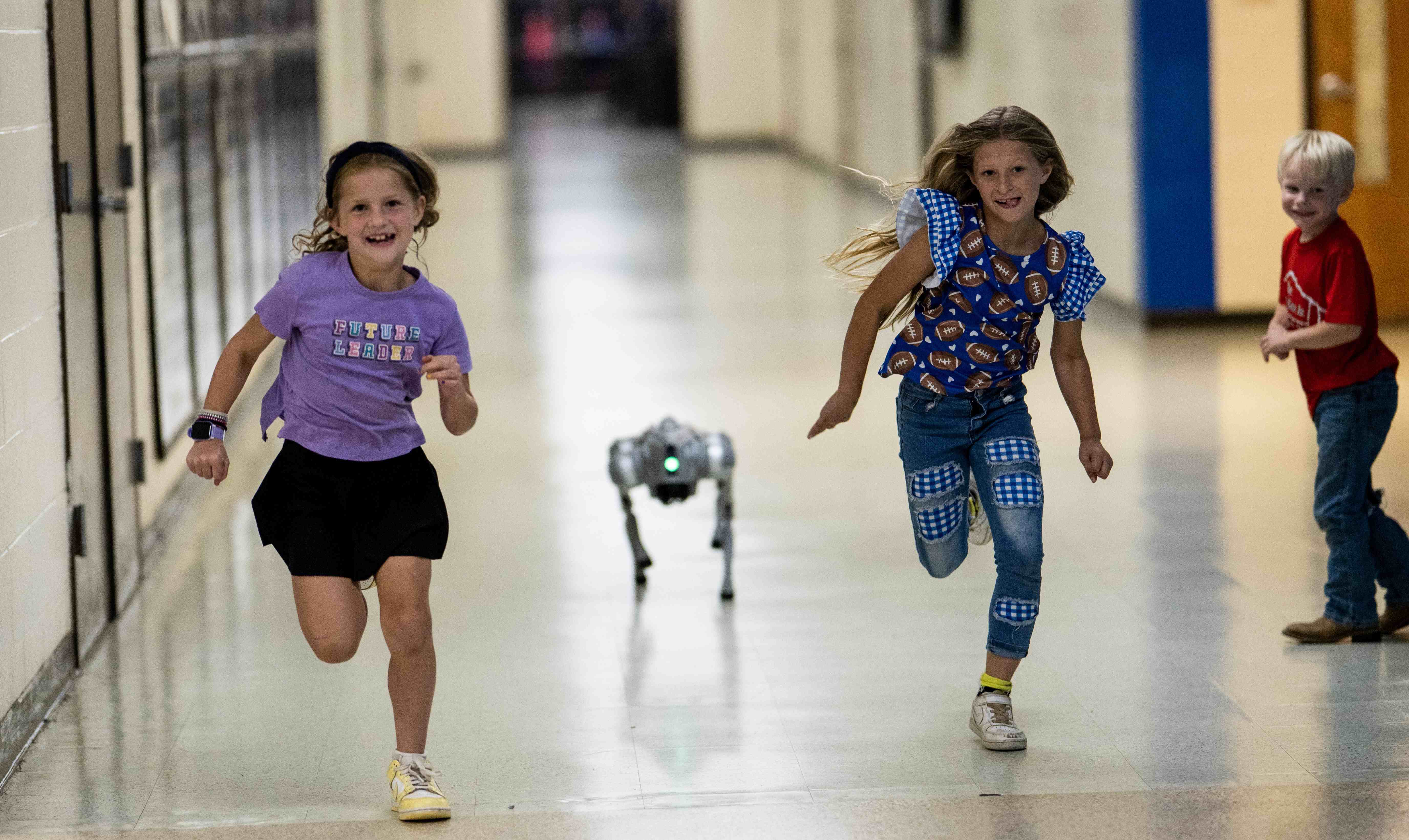 two girls running with the robo dog