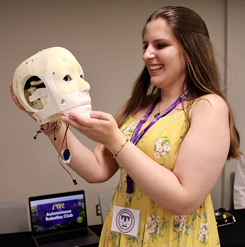 Deanna King holds the head of TALUS, a robot that resembles a human.