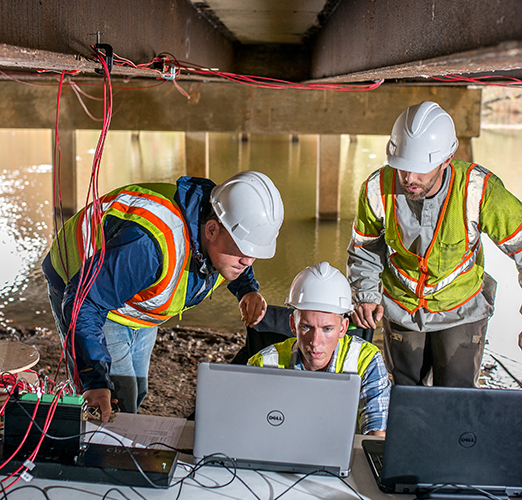 Civil engineering students settng sensors on a bridge