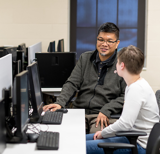 Students and faculty talking in a computer lab