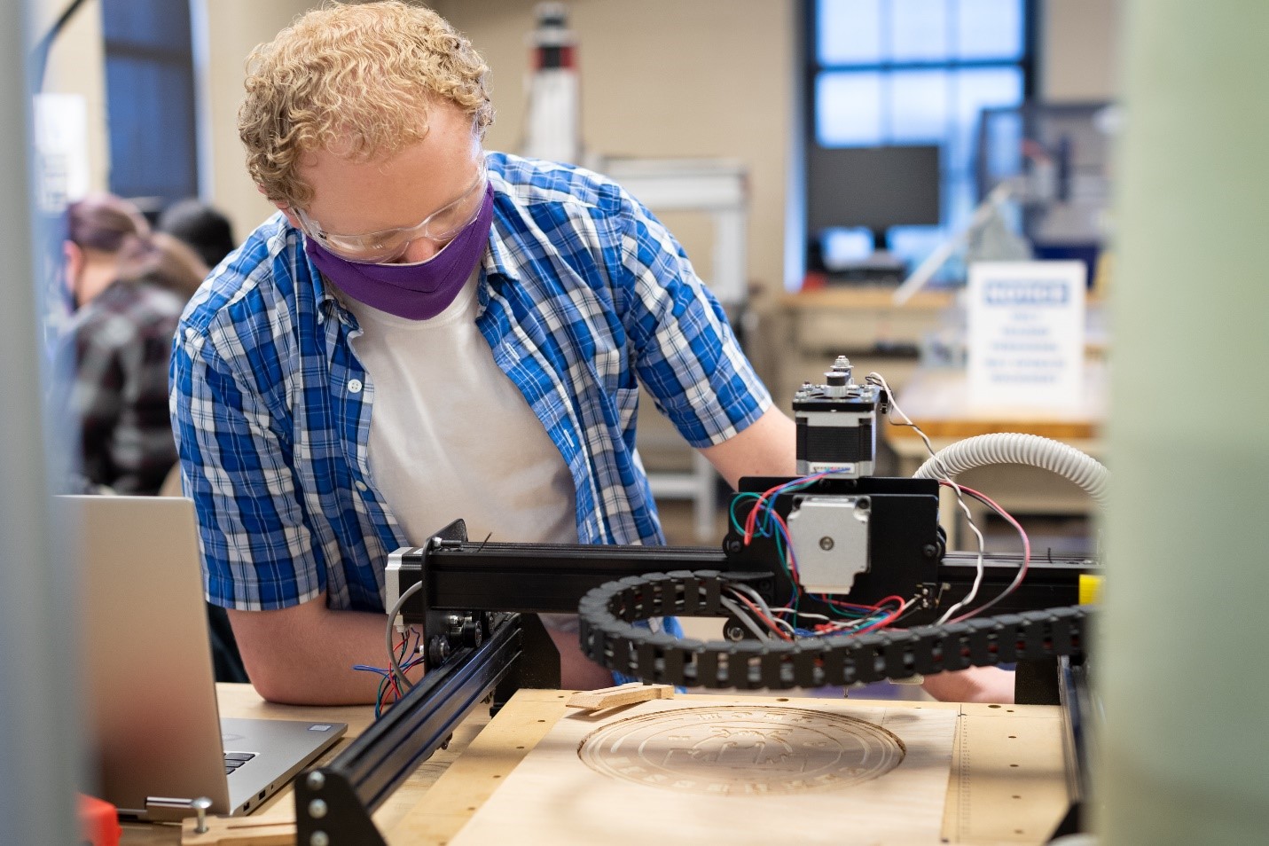 Student working with 3D printer in the iMakerspace at Tech