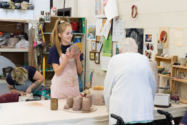 A young woman and an older woman working clay together