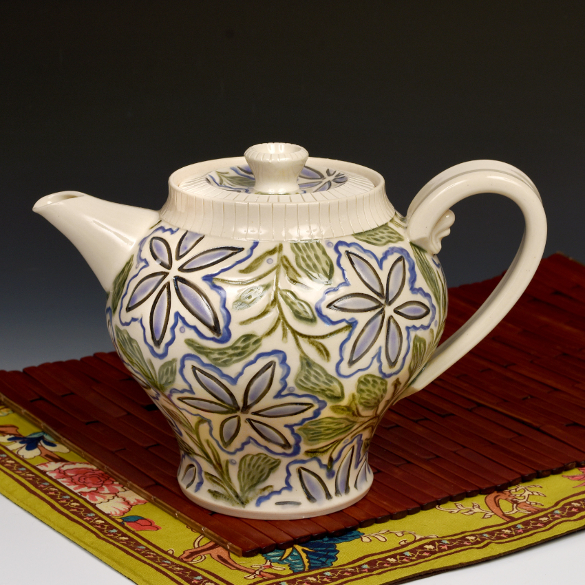 A clay teapot with flowers