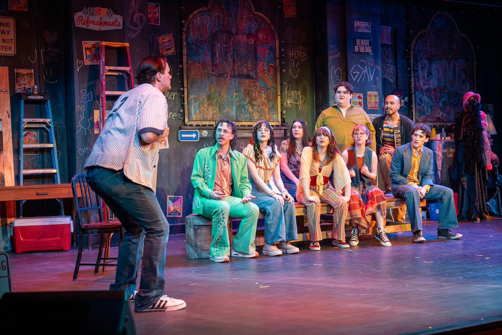 Godspell, Jesus preaching to the others in a squating pose