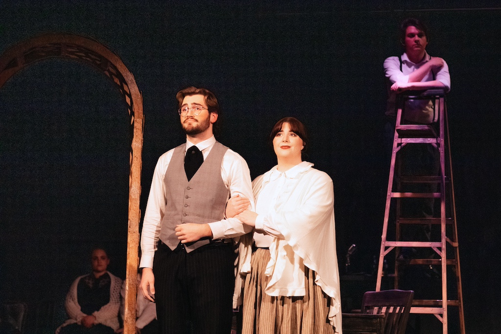Dr. and Mrs. Gibbs with George Gibbs on ladder in background, Our Town, on stage at the Backdoor Playhouse 