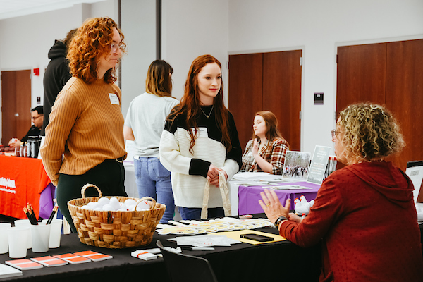 Students speaking with companies at a career fair.