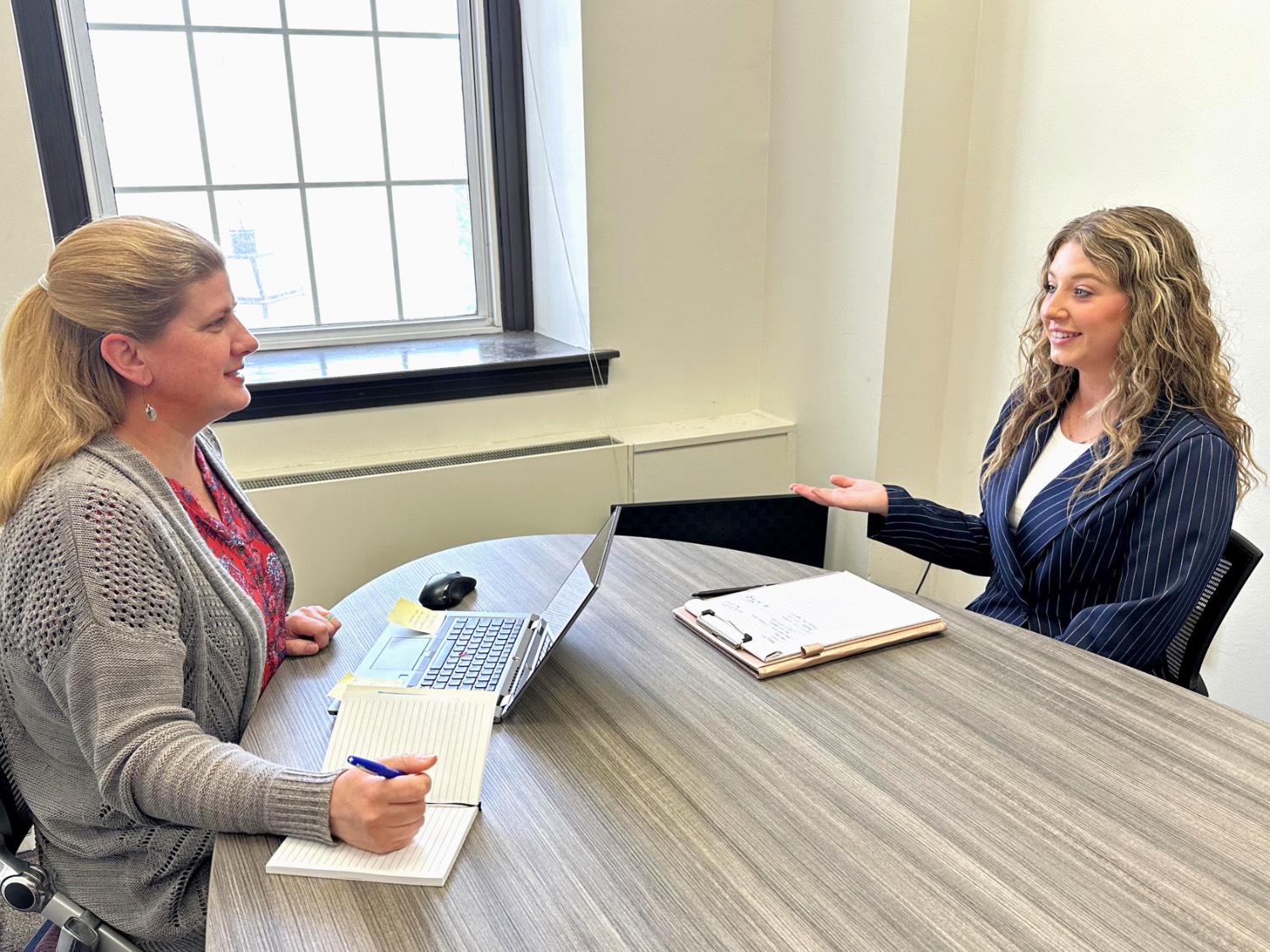 two women setting at a table taking part in an interview