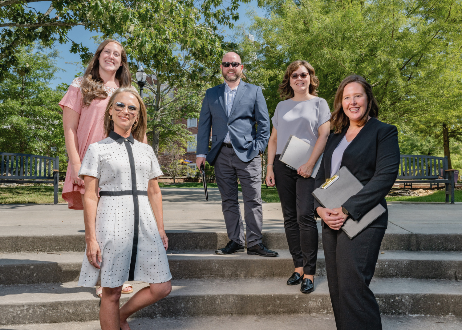 a group of people in business clothes standing outside smiling