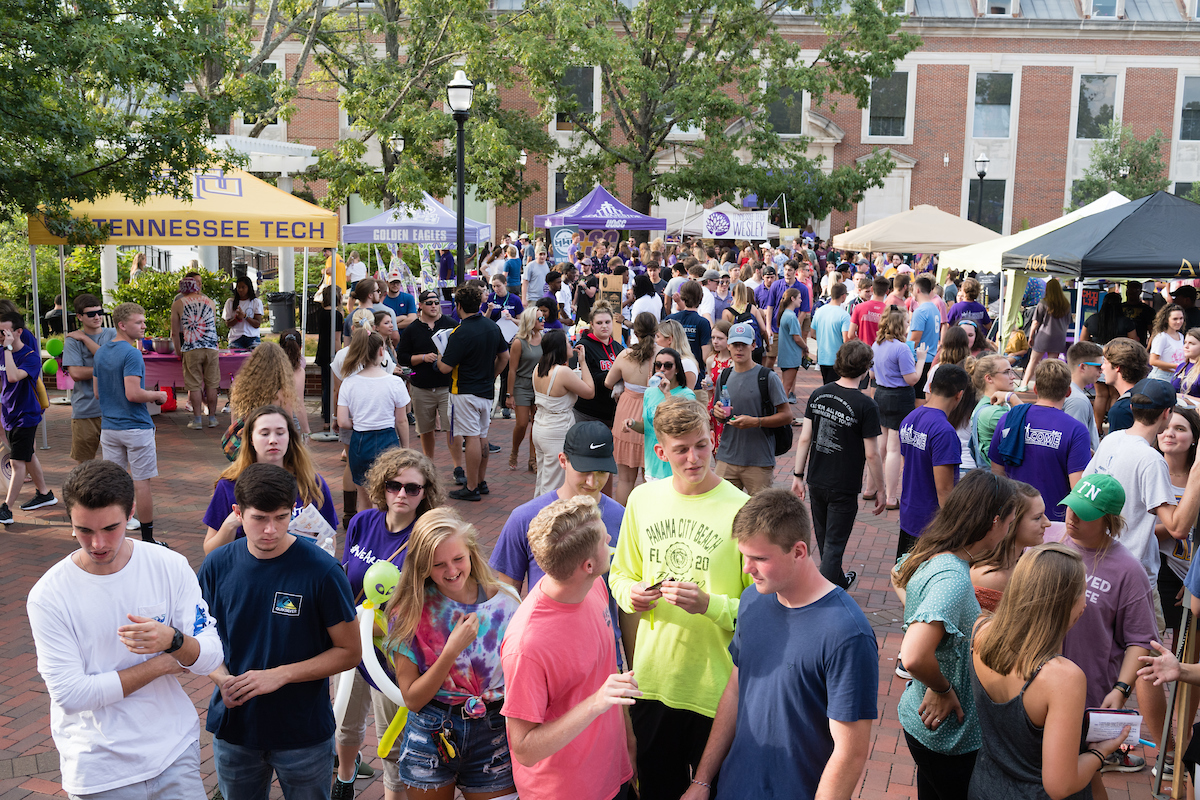 Students visiting organization tents.
