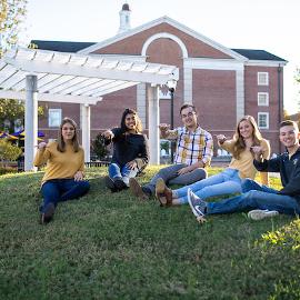 A group of students giving a Wings Up to the camera.