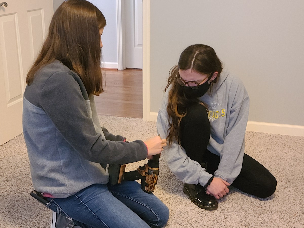 Tennessee Tech mechanical engineering students Emily Carroll and Lexie Carrier help install a sensory swing for an autistic child.