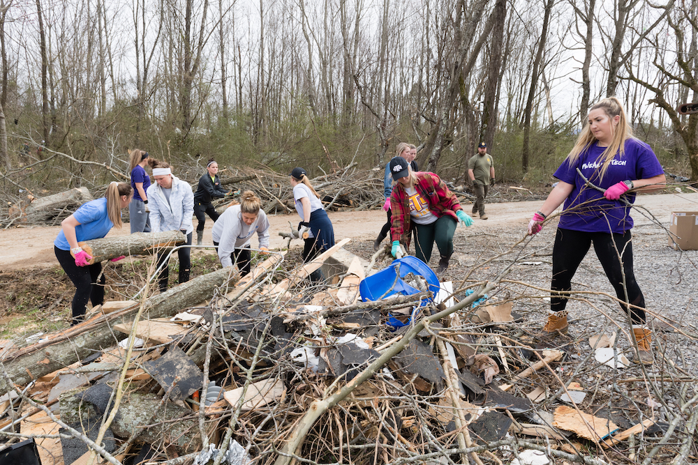 Members of Tennessee Tech’s softball team help with clean-up efforts on Wednesday in a neighborhood close to campus that was devastated by on F-4 tornado on Tuesday.