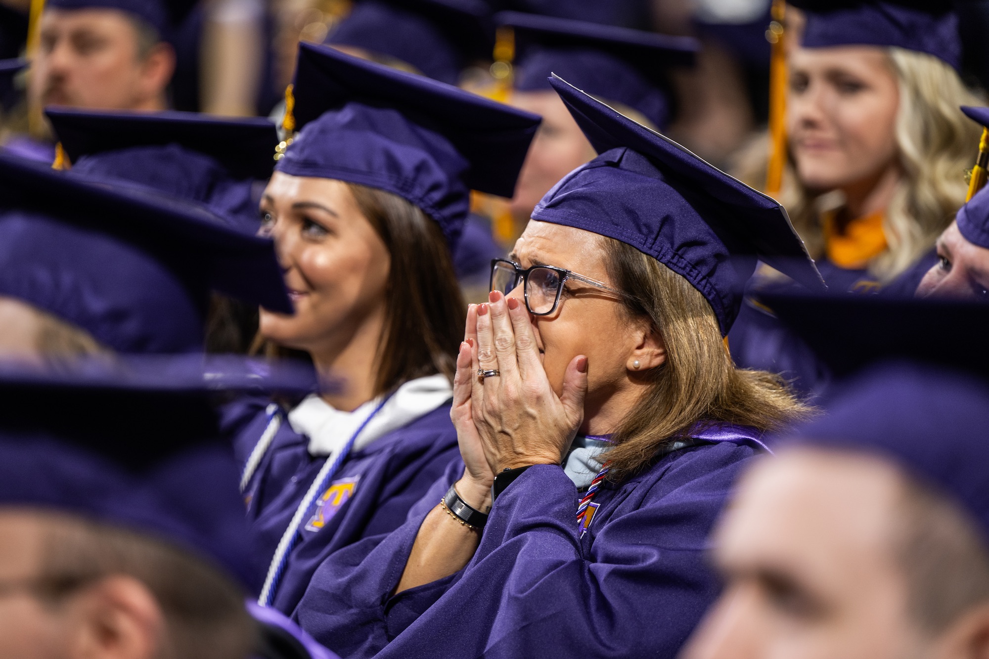 Jennifer Duggin, who graduated with her master's degree, reacts to a surprise video from her son, who is deployed in the U.S. Army.