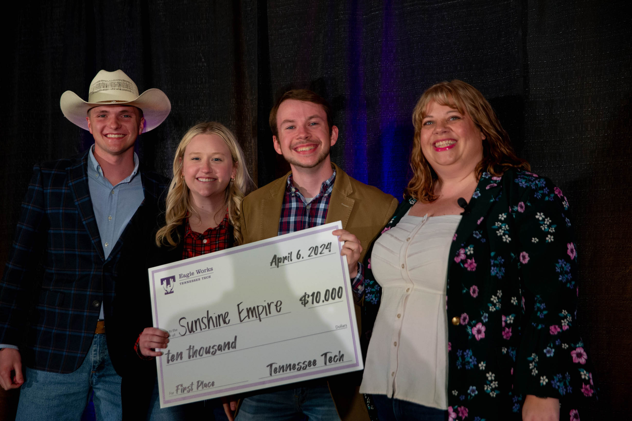 From left: Tech students Porter Davison, Addison Dorris, and Riley Bishop pose with their $10,000 first place scholarship prize alongside Eagle Works manager Andrea Kruszka. Photo credit: Ryan Hall