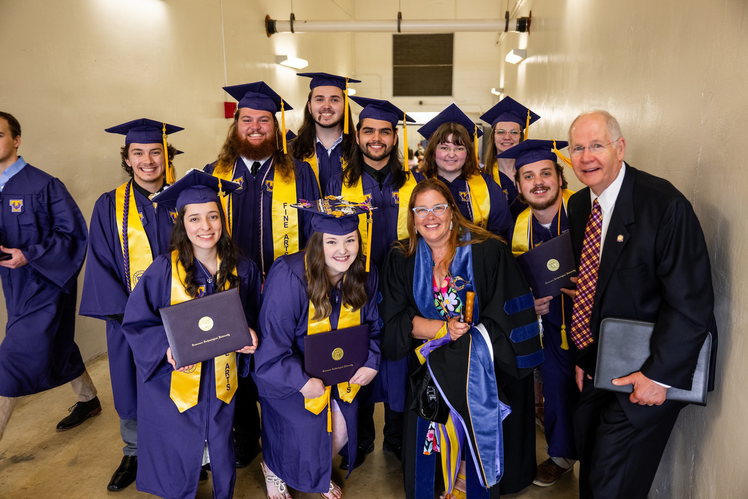 Dean Jennifer Shank and Tech alumnus Bob Luna pose with graduates from the university's College of Fine Arts. 