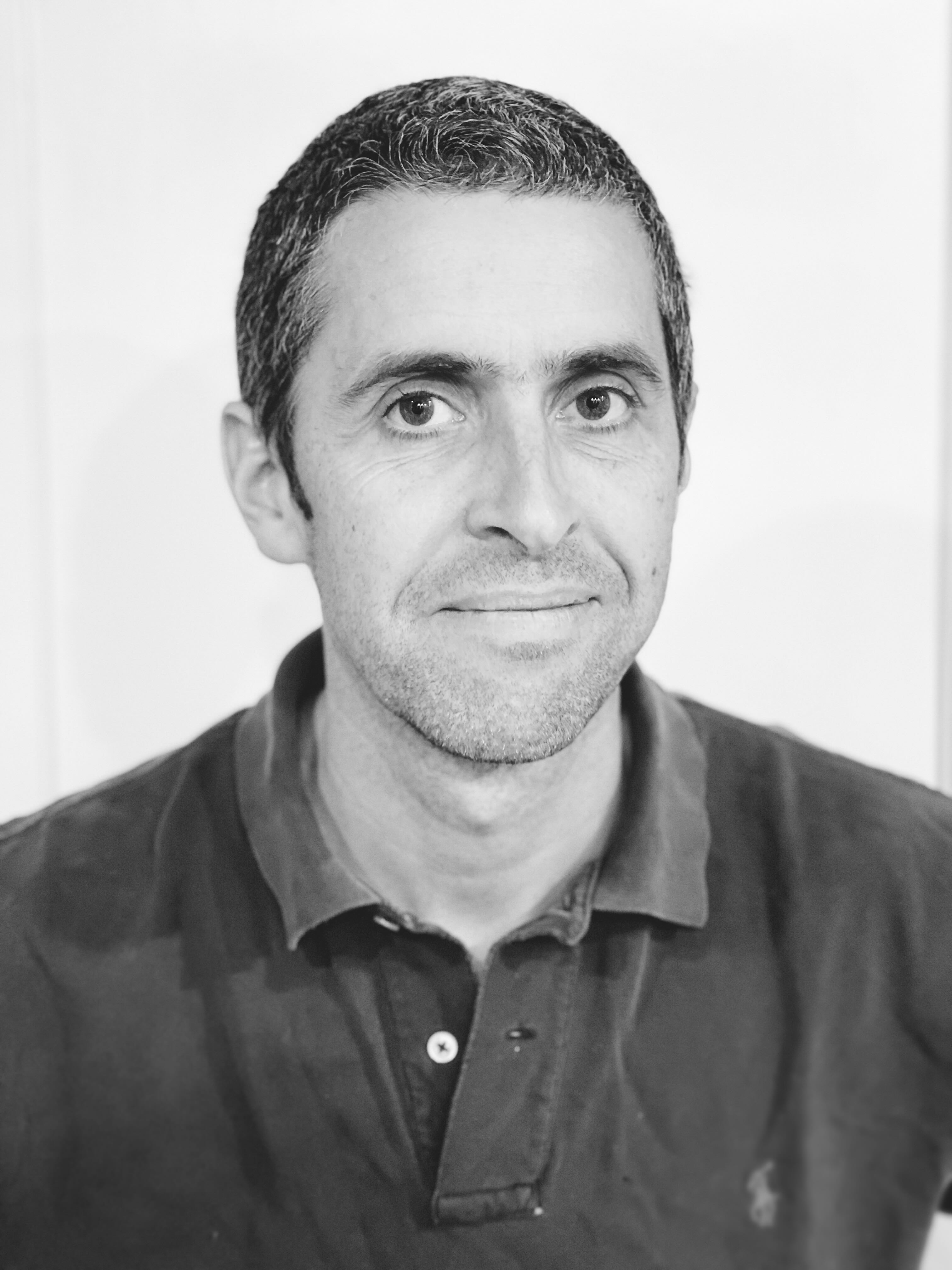 Professional black and white headshot of Damon MacNaught in a Polo shirt. 