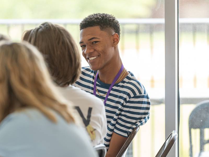 Student smiling at another student