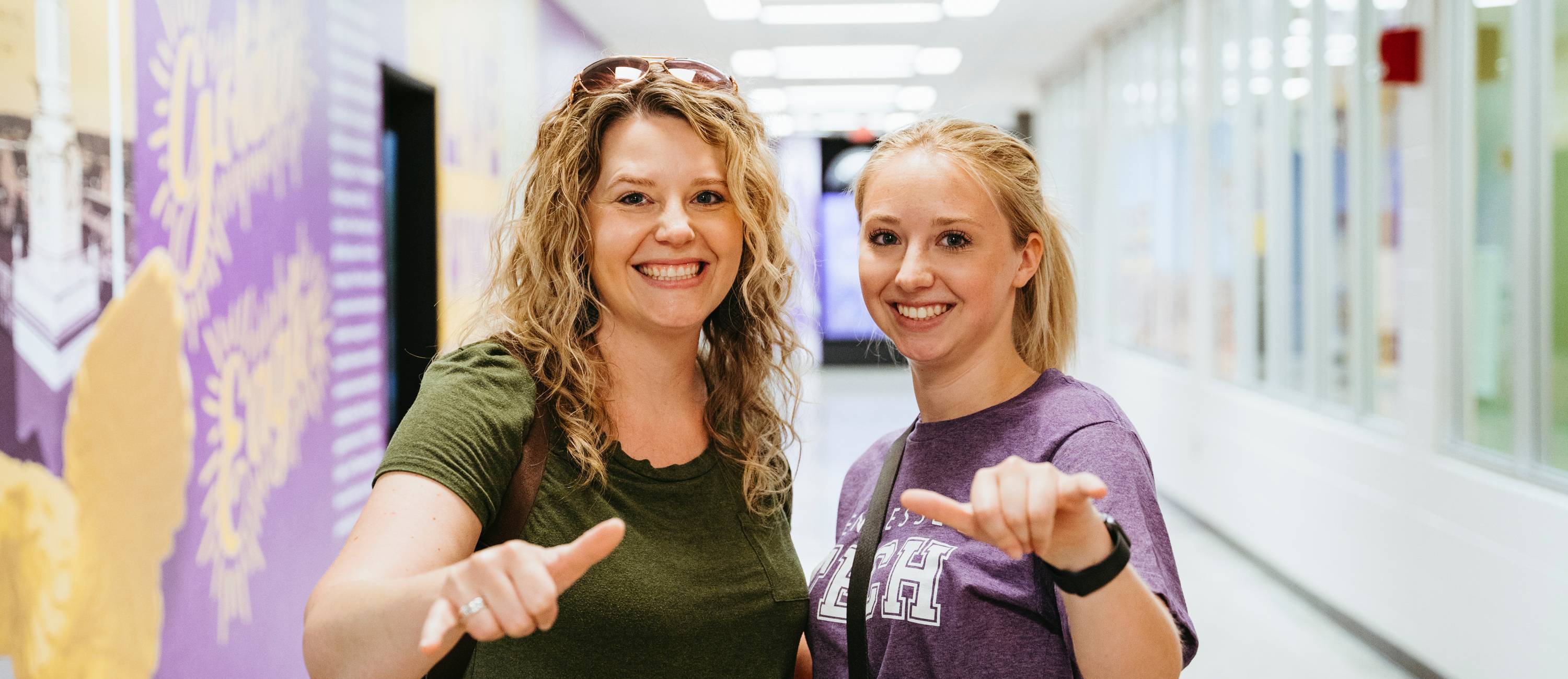 Student and parent giving wings up sign