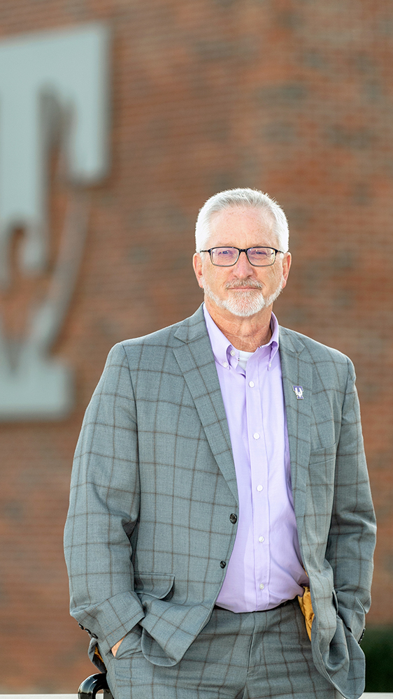 President Oldham posing in front of Lab Science Commons.