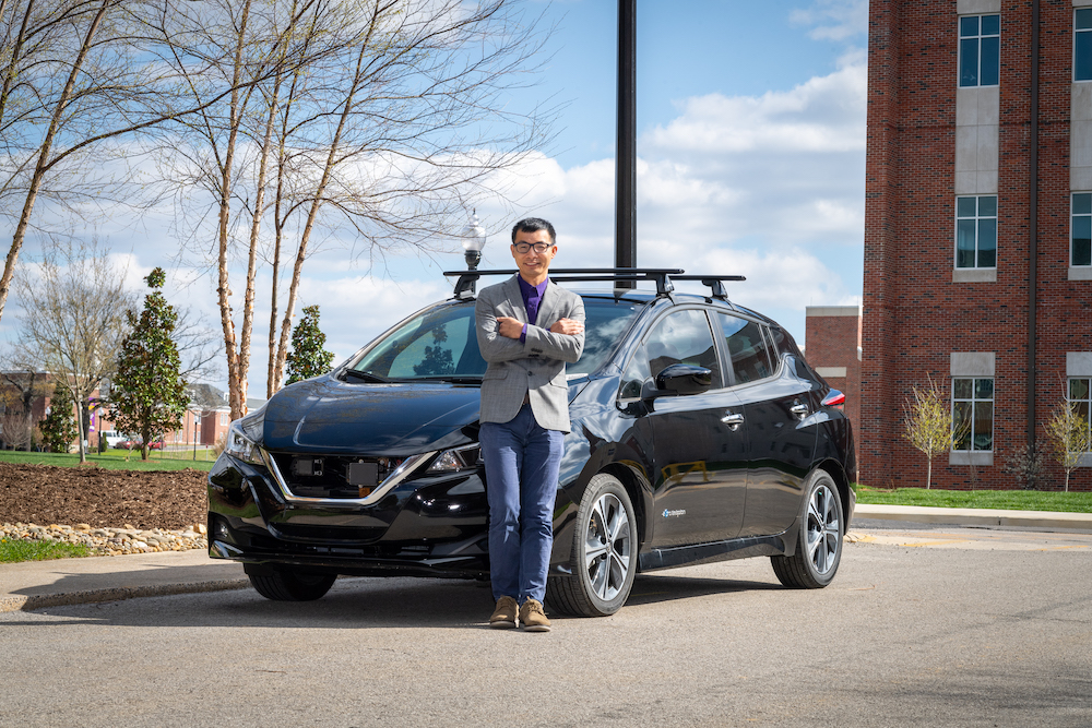 Pigen Chen is pictured with an electric vehicle.