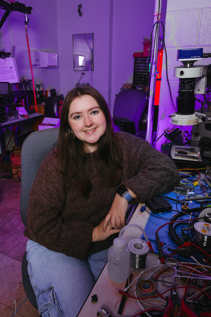 Lucy Dunn, a Computer Engineering major at Tennessee Tech, inside a Brown Hall lab with purple lighting.