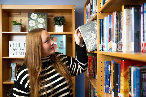 Kelsey Hewitt choosing a book from the Jeffers Learning Resource Center