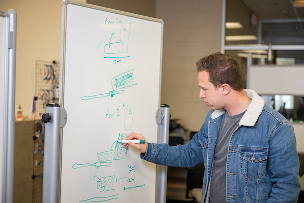 Zakary Henson drawing his prosthetic design