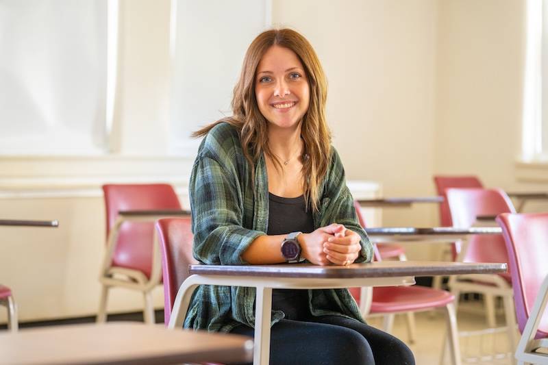 Gracey Bryant Senior psychology major Gracey Bryant sitting in a classroom smiling at the camera.