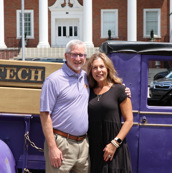 President Phil Oldham and First Lady Kari Oldham smile in front of the Pep Truck. 