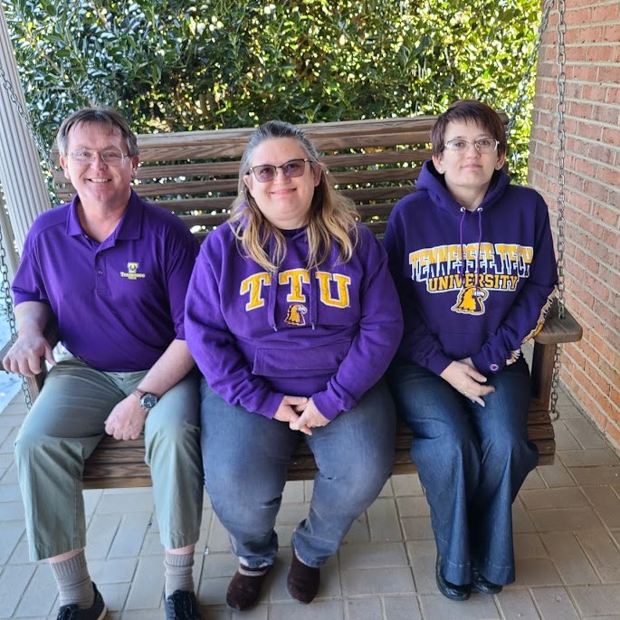 Lelia Gibson (center) sits with her brother and sister on a porch swing.