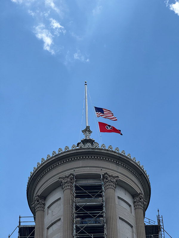 The American Flag and Tenneessee Flag at half-mass on at the top of a capital building.
