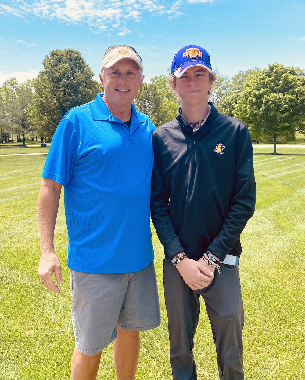 A photo of Darren and Alexander Bassel on the golf course.