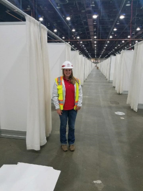 Peyton Abernathy in a hard hat and neon yellow vest standing in a temorary hospital in Detroit.