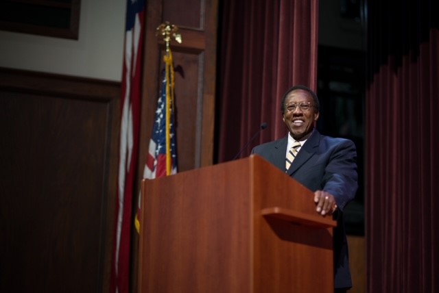 A photo of Dr. Leo McGee smiling at a lecturn.