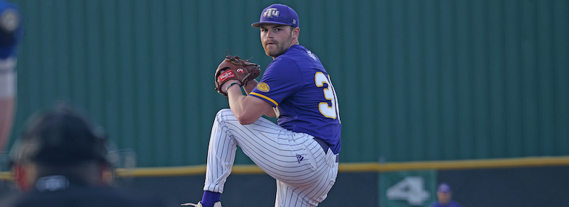 A baseball player winds up to pitch