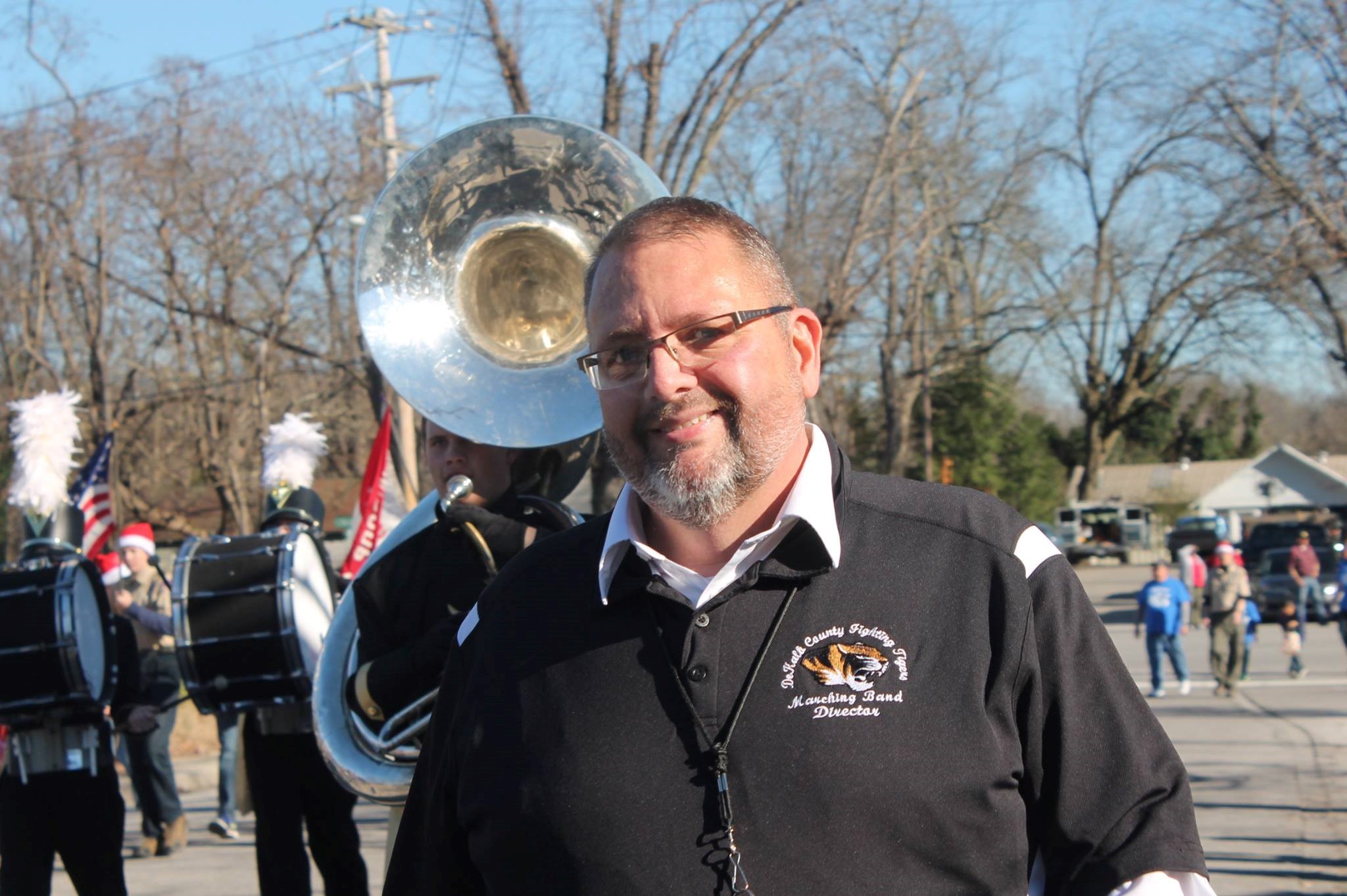 Tracy Luna stands in front of a marching band