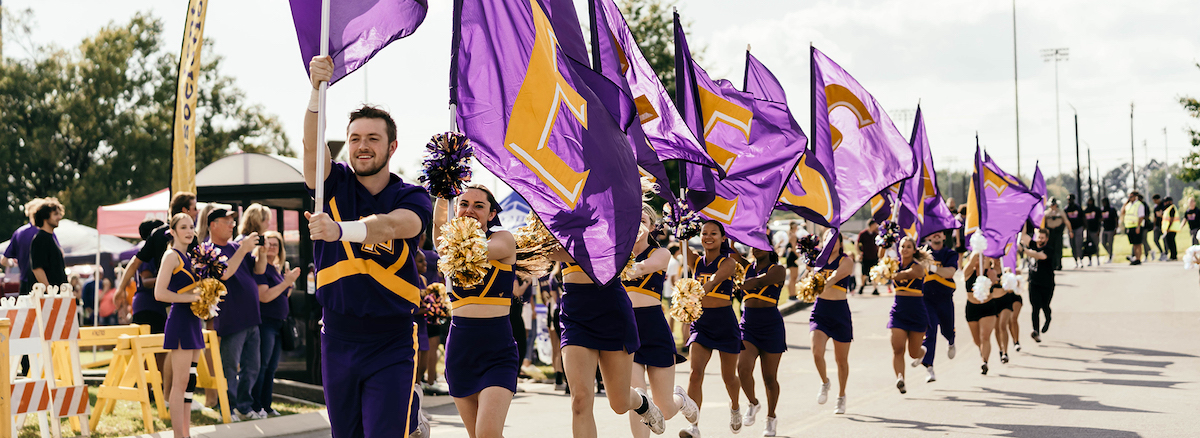 Cheerleaders running with flags