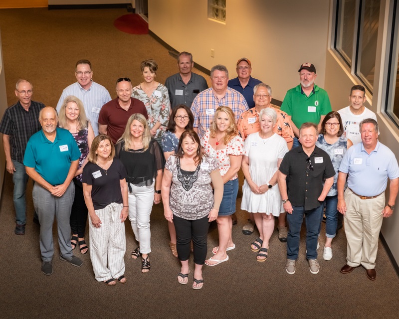 Part of the group of alumni smile up at the camera.