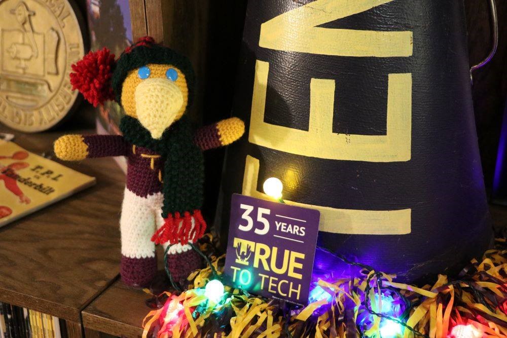 A photo of a small, crocheted Awesome Eagle posed beside Tech memorabilia.